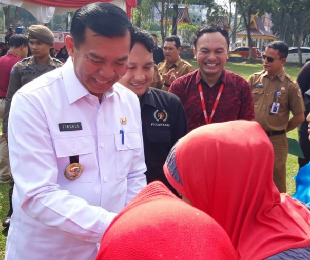 Wali Kota Pekanbaru Firdaus bersama Ketua Yayasan Pewarta Pekanbaru Adrian Eko saat menyalurkan bantuan sembako kepada emak-emak yang terdaftar sebagai PKH, Senin (21/10/2019). Foto: Istimewa.