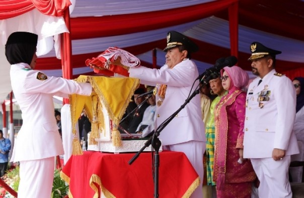 Gubernur Riau, Syamsuar menyerahkan bendera merah putih saat pelaksanaan upacara Kemerdekaan ke-74 RI 