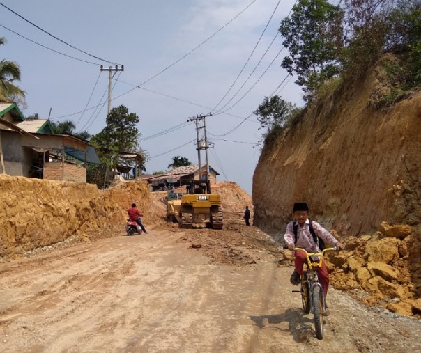 Seorang bocah SD saat melalui Jalan Badak Ujung, Kecamatan Tenaya Raya, yang sedang dibangun. Foto: Surya/Riau1.