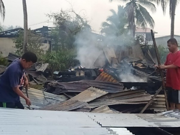 Tampak dua orang warga yang menjadi korban membersihkan puing-puing sisa kebakaran