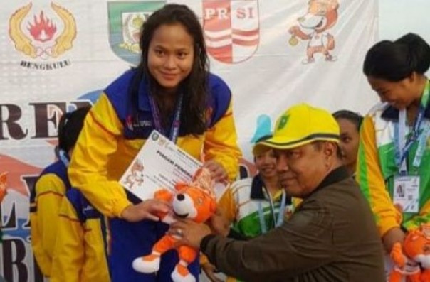 Ketua KONI Riau, Emrizal Pakis saat menyerahkan medali emas kepada atlet renang Riau yang meraih medali emas