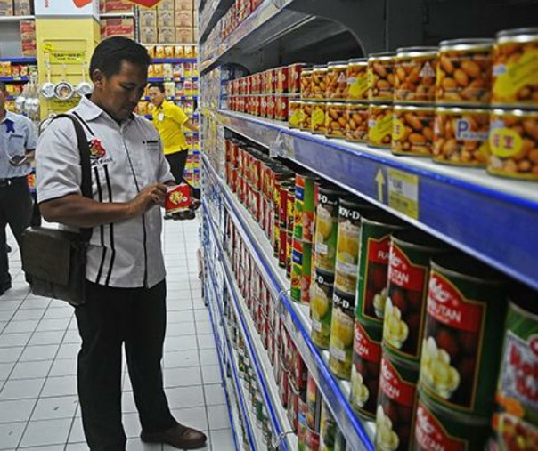 Anggota Satreskrim memeriksa sejumlah makanan saat razia makanan kedalurwarsa di salah satu pusat perbelanjaan. Foto: Antara.
