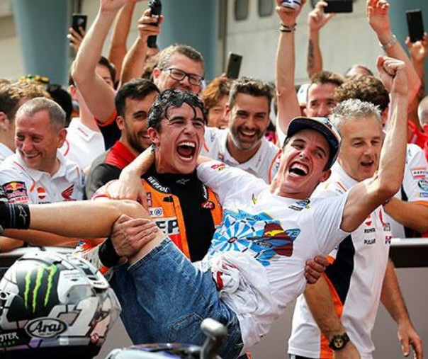 Pembalap Repsol Honda Marc Marquez menggendong adiknya Alex Marquez saat merayakan posisi kedua di Malaysia lalu. Foto: Reuters. 