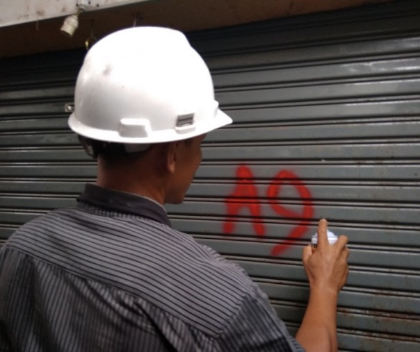 Karyawan PT MPP, pengelola Pasar Sukaramai, memberi tanda kios yang akan dibongkar, Selasa (19/11/2019). Foto: Surya/Riau1.
