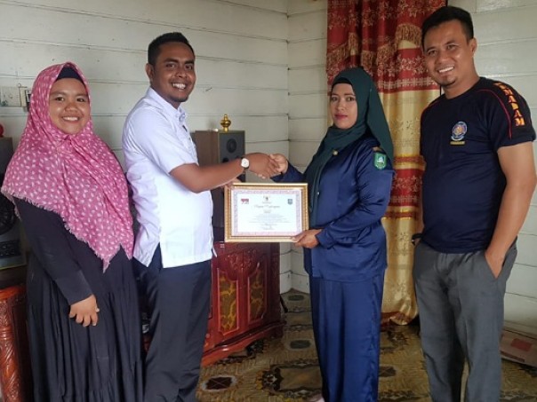 Komisioner KPU Bengkalis menyerahkan penghargaan kepada keluarga Zainal