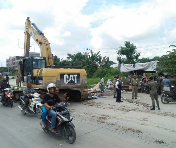 Petugas Satpol PP Pekanbaru mengerahkan alat berat untuk penggusuran ruli di Jalan Siak II, Rabu (27/11/2019). Foto: Istimewa.
