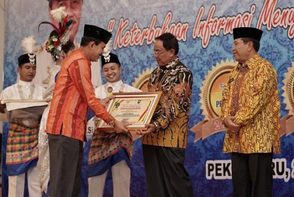 Bupati Inhil saat menerima piagam penghargaan KI Riau 2019