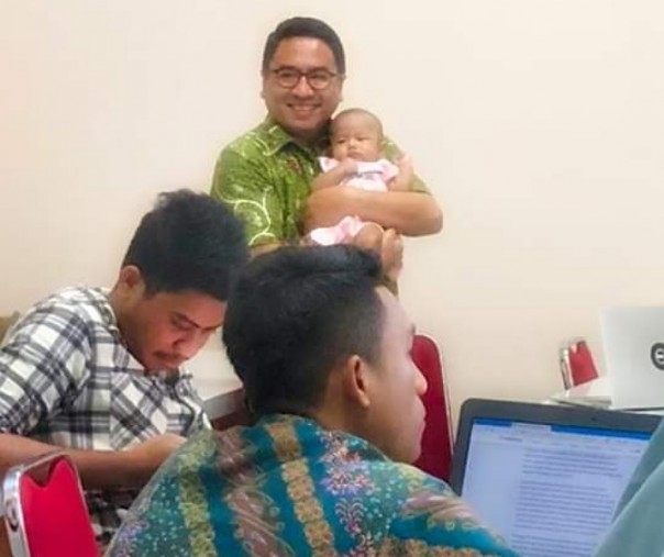 Abdul Gaffar menggendong bayi [Foto: Istimewa/Facebook]