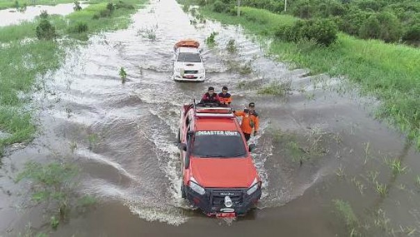 Tim BPBD Pelalawan menerjang banjir yang menggenangi jalan