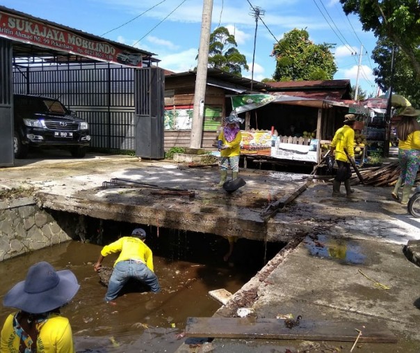 Para pekerja dari Dinas PUPR Pekanbaru saat membersihkan drainase di Jalan Arifin Ahmad. Foto: Surya/Riau1.