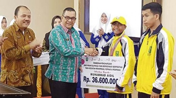 Kepala Dispora Riau, Doni Aprialdi mendampingi Wagubri, Edy Natar saat penyerahan bonus untuk atlet pelajar Riau yang berprestasi di Popnas, Perpenas dan Pospenas 2019