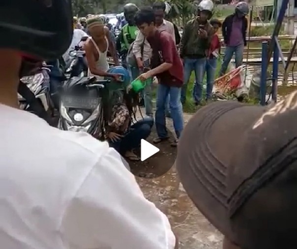 Screenshoot video cewek geleng-geleng kepala di pinggir jalan hingga diguyur air oleh warga. Kabarnya, kejadian tersebut di Kota Pekanbaru.