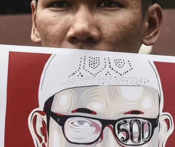 Seorang pendukung memegang karikatut penyidik seniot KPK Novel Baswedan. Foto: Antara.