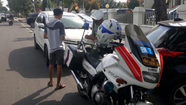 Petugas Satlantas Polresta Pekanbaru menindak pelanggar yang parkir di trotoar Jalan Sudirman