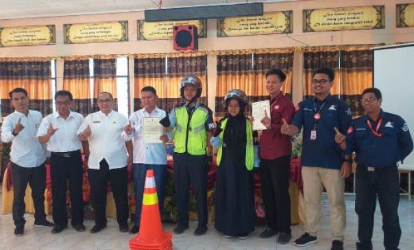 Tim Safety Riding Capella Honda Riau menyerahkan perlengkapan keselamatan berkendara kepada SMKN 2 Dumai