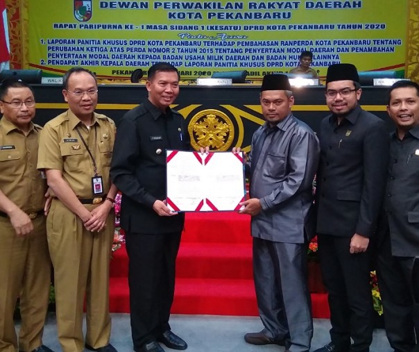 Ketua DPRD Hamdani (kanan) bersama Wali Kota Pekanbaru Firdaus (kiri) melihatkan dokumen yang telah ditandatangani, Senin (27/1/2020). Foto: Surya/Riau1.
