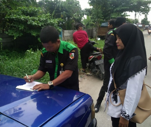 Petugas dari Satgas DLHK Pekanbaru saat menangkap basah warga yang buang sampah sembarangan. Foto: Istimewa.