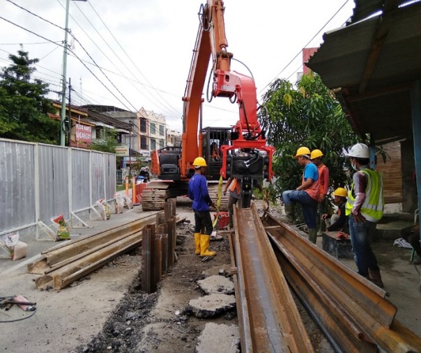 Para pekerja proyek IPAL sedang menanam besi baja untuk melubangi aspal di Jalan Ahmad Dahlan Pekanbaru. Foto: Surya/Riau1.