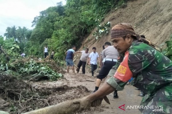 Warga dan aparat TNI Polri membersihkan tanah longsor di Kabupaten Padang Pariaman, Rabu. 
