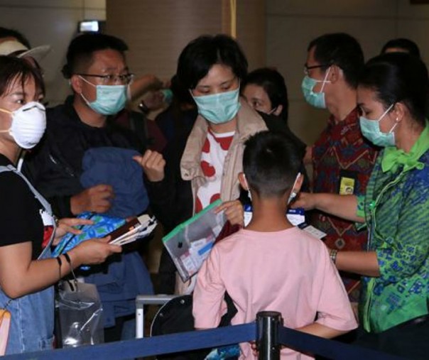 Petugas memeriksa tiket penumpang pesawat maskapai China Southern Airlines tujuan Guangzhou, China, di Terminal Keberangkatan Internasional Bandara Internasional I Gusti Ngurah Rai, Bali. Foto: Antara.