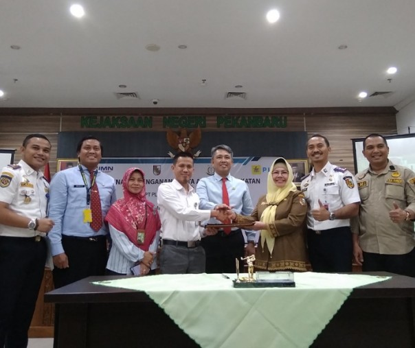 Pihak PLN bersalaman dengan Asisten II Setdako Pekanbaru El Syabrina yang difasilitasi Kajari Pekanbaru Andi Suharlis. Foto: Surya/Riau1.