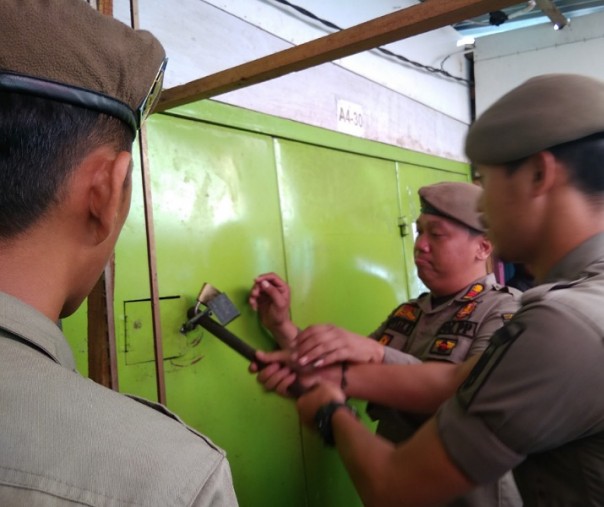 Petugas Satpol PP Pekanbaru saat membongkar kios pedagang korban kebakaran 2015 di tempat penampungan sementara, beberapa waktu lalu. Foto: Surya/Riau1.