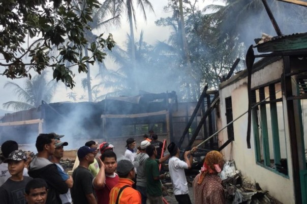 Petugas dan warga saat memadamkan kebakaran rumah di Solok, Minggu. 