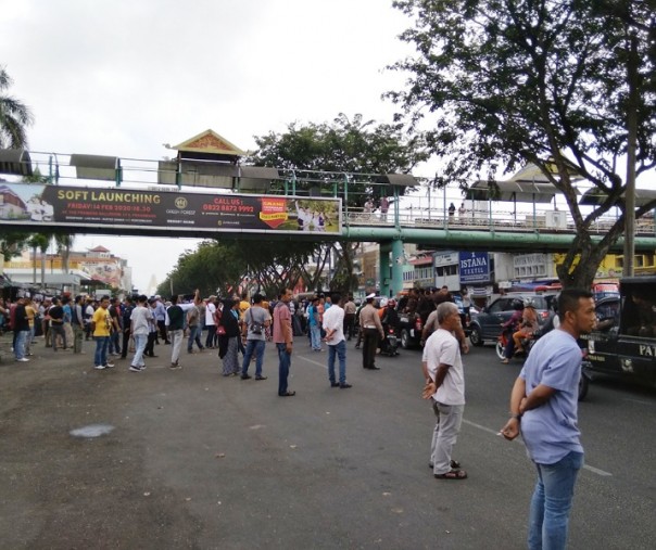 Ratusan pedagang korban kebakaran 2015 mengadang konvoi mobil Satpol PP Pekanbaru di Jalan Jenderal Sudirman, Selasa (25/2/2020). Foto: Surya/Riau1.