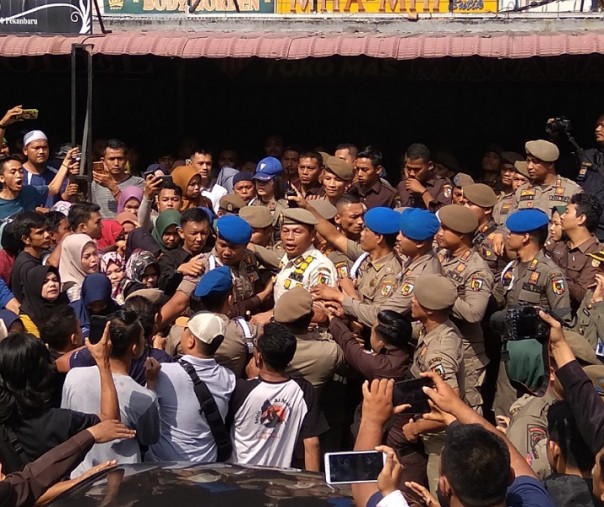Kepala Satpol PP Pekanbaru Agus Pramono dikeliling anggotanya saat terjadi dorong-dorongan dengan pedagang di kawasan STC, Selasa (25/2/2020). Foto: Surya/Riau1.