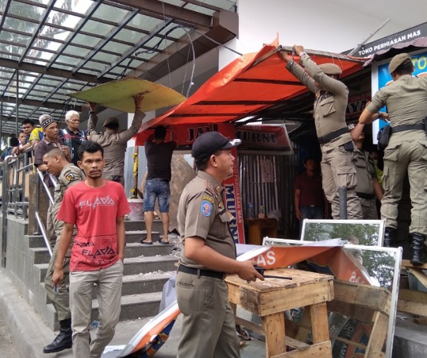 Petugas Satpol PP Pekanbaru saat membongkar lapak pedagang di salah satu kios TPS kawasan STC, Selasa (25/2/2020). Foto: Surya/Riau1.