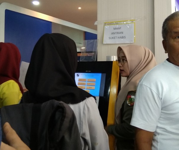 Petugas Satpol PP Pekanbaru saat melayani pengunjung Disdukcapil di mesin nomor antrean, Kamis (27/2/2020). Foto: Surya/Riau1.