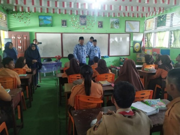 Sekdakab Inhu Hendrizal (tengah) didampingi Kadis Kesehatan Inhu Ellis Julinarti, Kepala Sekolah SMPN 1 Rengat Barat Raja Aini dan petugas medis Puskesmas Pekanheran ketika melakukan Sidak diruang kelas SMPN 1 Rengat Barat, Selasa 17 Maret 2020.