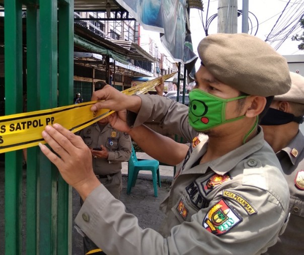 Petugas Satpol PP Pekanbaru menyegel Warnet MGC di Jalan Kaharuddin Nasution, Jumat (27/3/2020). Foto: Surya/Riau1.