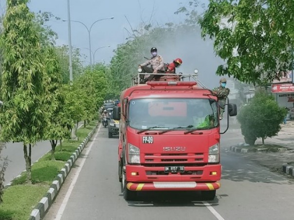 Proses penyiraman disinfektan di Tualang Siak