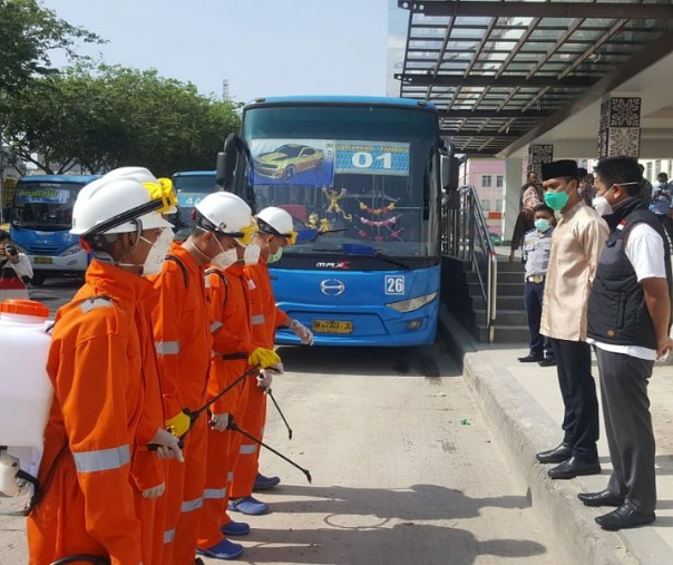 Kepala Dishub Pekanbaru Yuliarso (dua dari kanan) saat memberikan pengarahan kepada petugas yang menyemprotkan cairan disinfektan. Foto: Dishub Pekanbaru.