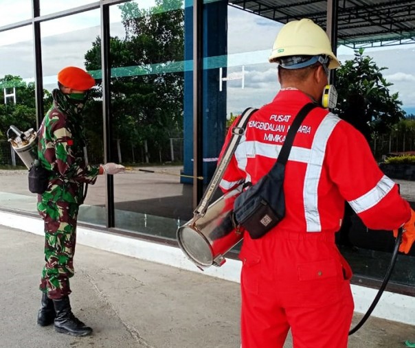 Paskhas TNI AU Pekanbaru bersama petugas Dinkes Mimika Papua menyemprotkan cairan disinfektan di sekitar Bandara Mozes Kilangin, Sabtu (28/3/2020). Foto: Paskhas TNI AU Pekanbaru.