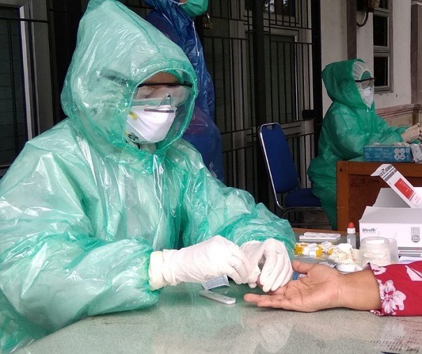 Petugas Puskesmas Simpang Tiga Pekanbaru melakukan mengambil sampel darah salah seorang warga untuk diuji di alat rapid test, Kamis (2/4/2020). Foto: Surya/Riau1.