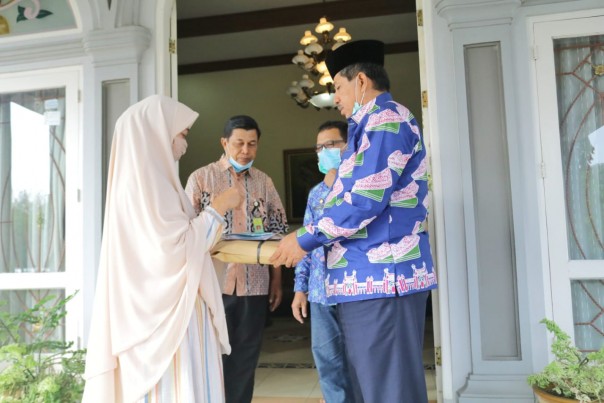 Ketua Dekranasda Kabupaten Siak Rasideh Alfedri menyerahkan bantuan masker kepada Bupati Siak Alfedri/R24