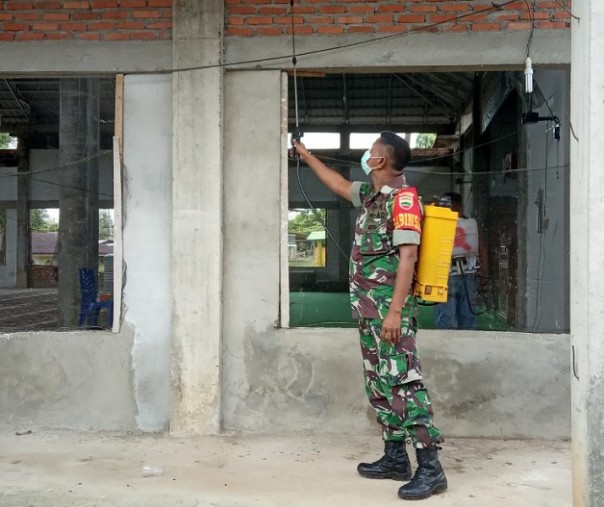 Banbinsa Ranah Sungkai Serda Janir Kamarudin menyemprotkan cairan disinfektan di rumah ibadah, Jumat (3/4/2020). Foto: Istimewa.