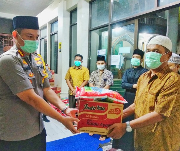 Kapolresta Pekanbaru Kombes Nandang menyerahkan bantuan kepada masyarakat.