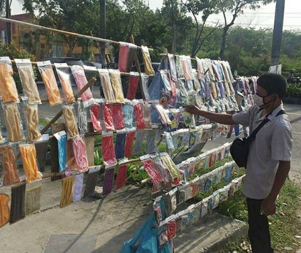 Pedagang lain beralih berjualan masker kain yang kian banyak diminati warga Pekanbaru di tengah wabah virus corona. Foto: Riau1.