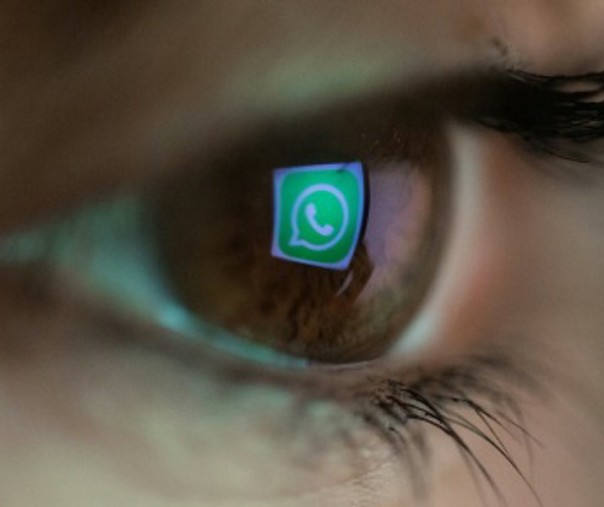 Gambar close-up logo WhatsApp di mata seorang. Foto: AFP.