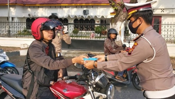 Kasatlantas Polresta Pekanbaru, Kompol Emil Eka Putra saat membagikan masker kepada pengendara dalam rangka imbauan bahaya virus corona