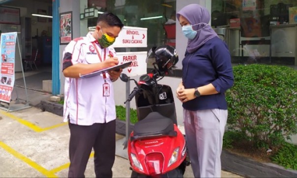 Mekanik AHASS Capella Honda Riau melayani konsumen wanita yang ingin servis sepeda motor
