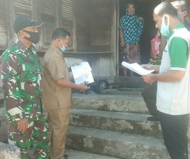 Babinsa Koramil 01 Bangkinang Kodim 0313 Kampar Pelda Afriandi saat mendampingi kades Muara Uwai mendata warga yang akan mendapat bantuan dari pemerintah, Rabu (6/5/2020). Foto: Istimewa.