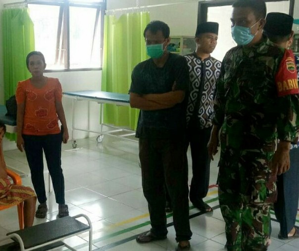 Babinsa Pematang Tebih Rohul Sertu Basridul mengevakuasi anak bocor jantung ke puskesmas terdekat, Kamis (14/5/2020). Foto: Istimewa.