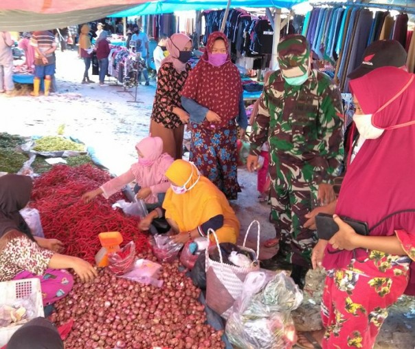 Babinsa Koramil 15 Kuala Kampar Kodim 0313 Kampar Kopda Roni saat mengecek harga bahan pokok di Pasar Induk Bukit Garam, Rabu (20/5/2020). Foto: Istimewa.