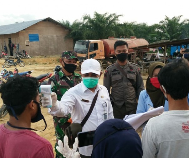 Petugas kesehatan Kabupaten Rohul saat mengukur suhu tubuh warga yang datang dari Medan, Kamis (21/5/2020). Foto: Istimewa.