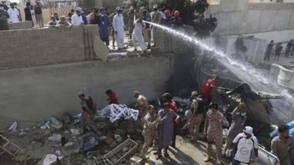 Inilah penampakan petugas mengevakuasi korban pesawat yang jatuh di Karachi, Jumat. 
