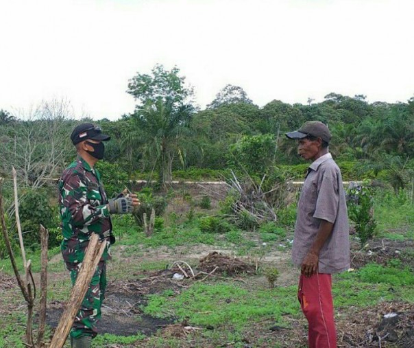 Babinsa Koramil 04 Pangkalan Kuras Kodim 0314 Kampar Serka Samsul Wahidin saat memberikan sosialiasi ke pekerja kebun di Desa Lubuk Kembang Bunga, Sabtu (23/5/2020). Foto: Istimewa.
